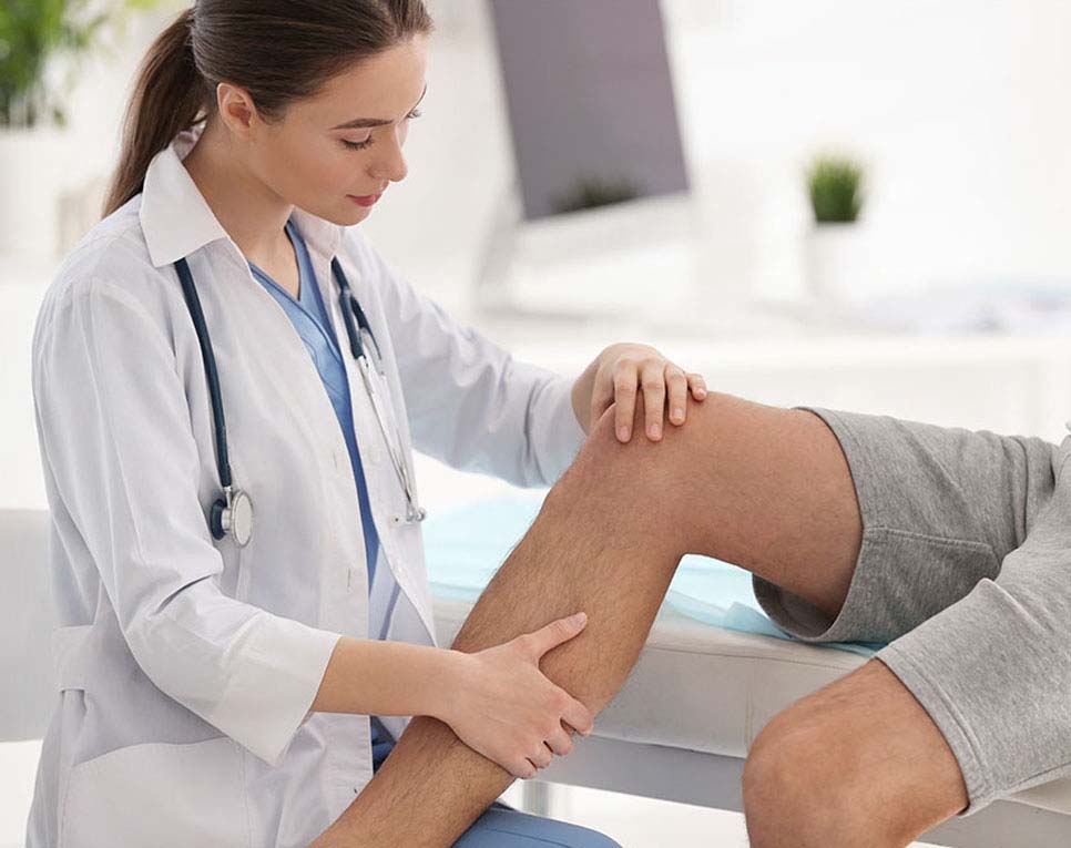Doctor examining patients knee joint for cause of pain