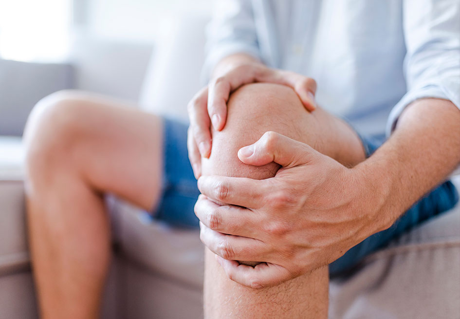 Man holding knee in pain from joint injury